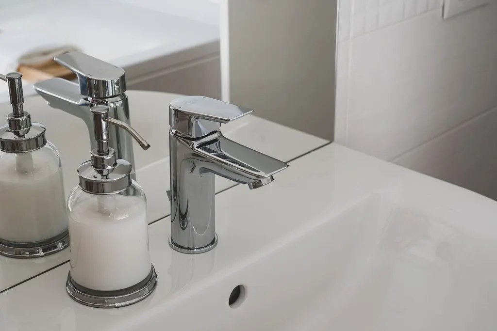 Lavabo con grifo cromado y dispensadores de jabón